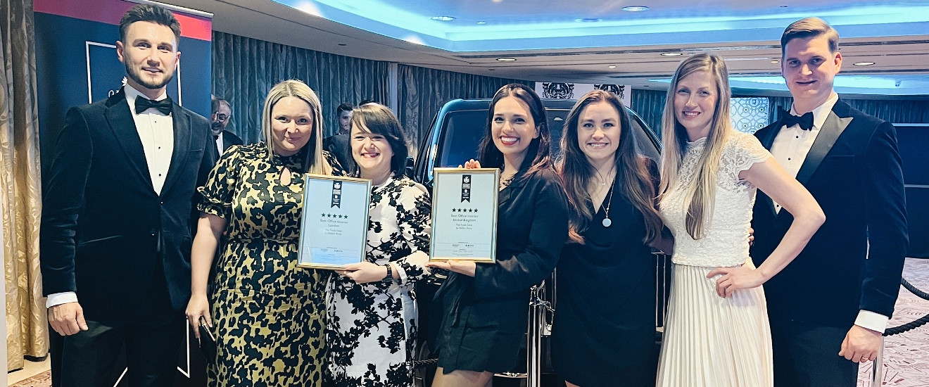 Peldon Rose team in formal attire holding award certificates.