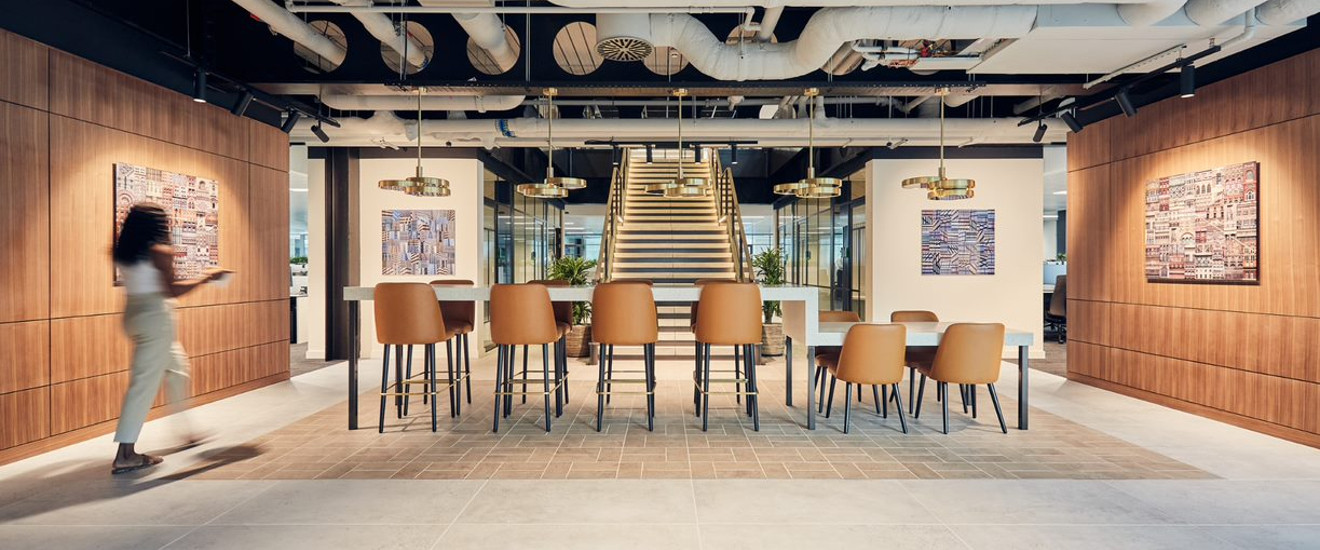 Modern open plan collaboration office space with soft lighting and staircase.