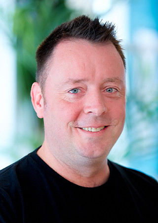 Mark Jordan Peldon Rose Headshot with a black tshirt.
