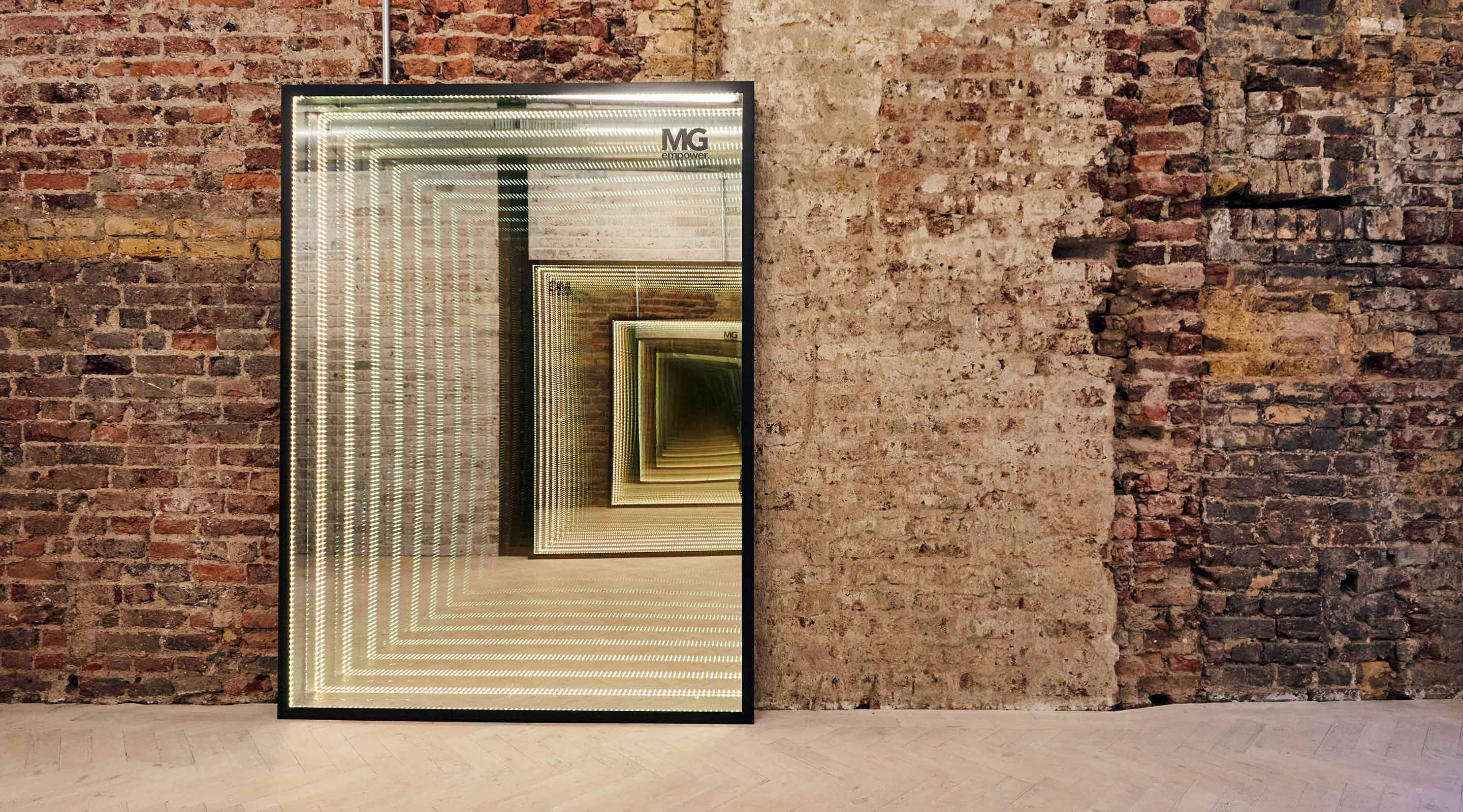 Exposed brick wall in office with light up infinity mirror