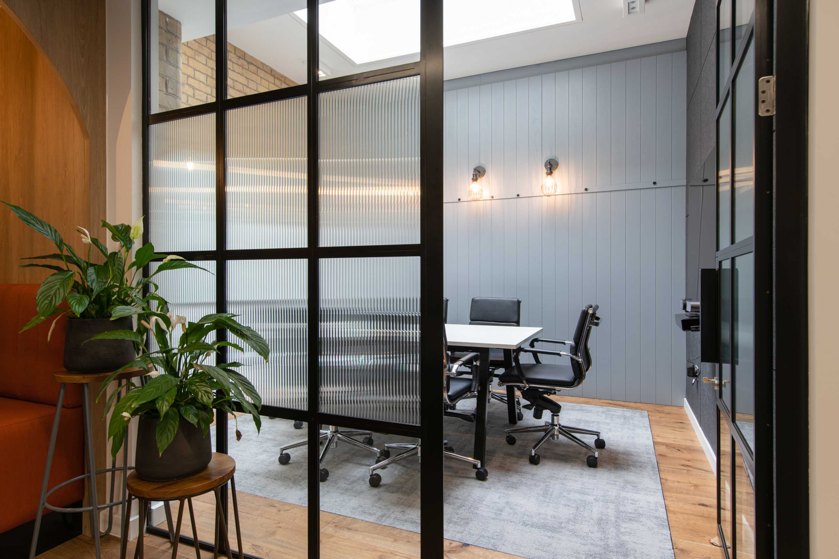 Office meeting room with table chairs lighting and biophilia