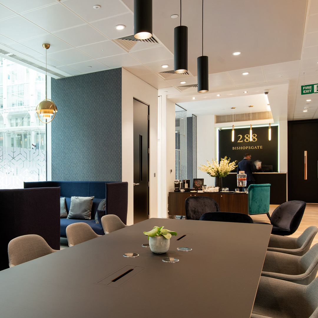 Modern office lobby with seating area, reception desk, and elegant decor.