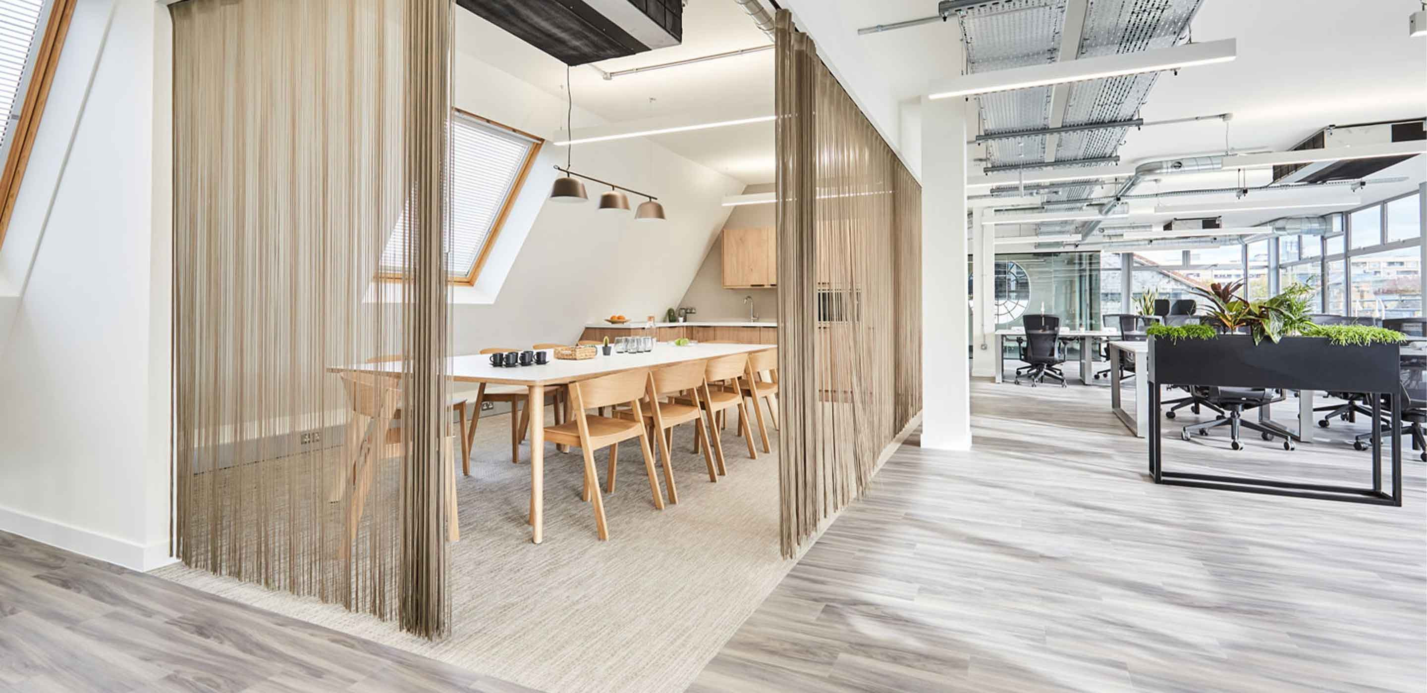 Coworking office with open plan layout featuring Scandi desks and chairs with biophilia and floor to celing windows